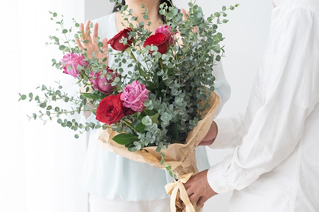 妻に花束を渡す夫
