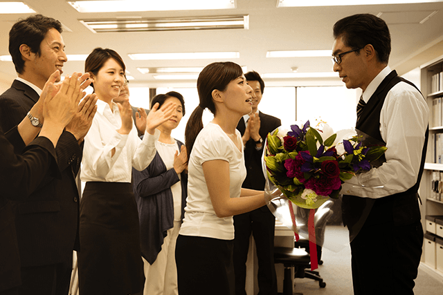 退職する上司に花束を渡す社員