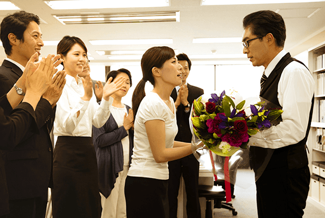 退職する上司に花束を渡す社員